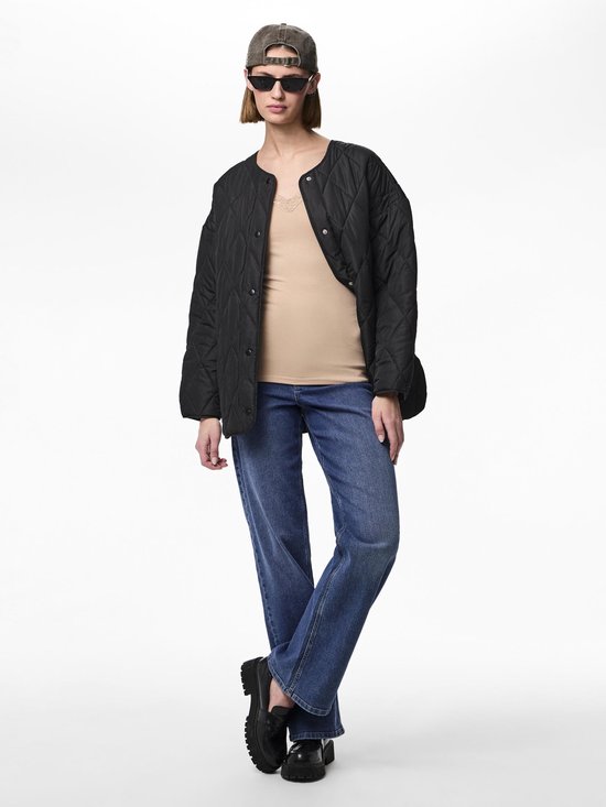Model draagt een beige hemdje, een zwarte doorgestikte jas, blauwe jeans, zonnebril en pet.