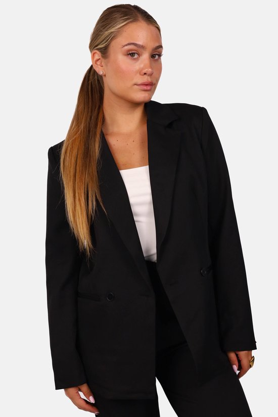 Zwarte oversized getailleerde blazer met knoopsluiting gedragen over een wit hemd.