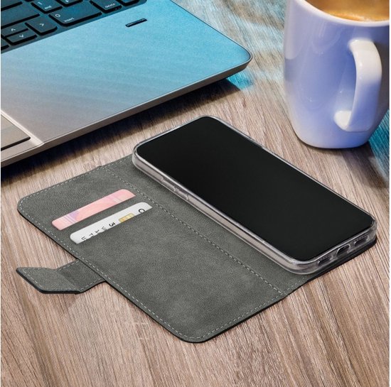 Étui portefeuille gris sur un bureau avec un ordinateur portable et une tasse de café.