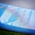 Gedetailleerde close-up van het blauwe en zwarte net van een trampoline.