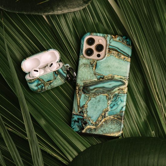 Telefoonhoes en AirPods-hoes met groen en goud marmerpatroon, liggend op groene bladeren.