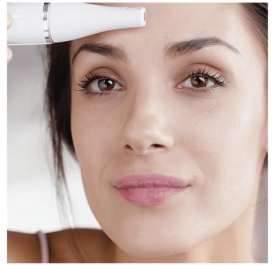 Gezicht van een vrouw met bruine ogen, die de punt van de witte Braun FaceSpa Pro op haar voorhoofd zet.