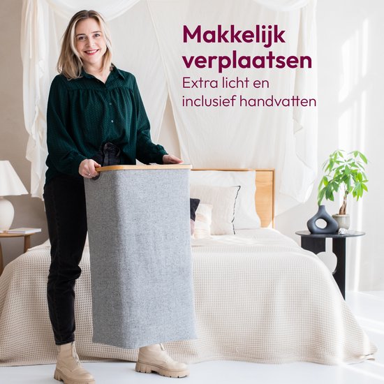 Vrouw in donkergroene blouse en grijze jeans tilt de grijze wasmand met bamboe deksel op. Tekst: 'Makkelijk verplaatsen'.