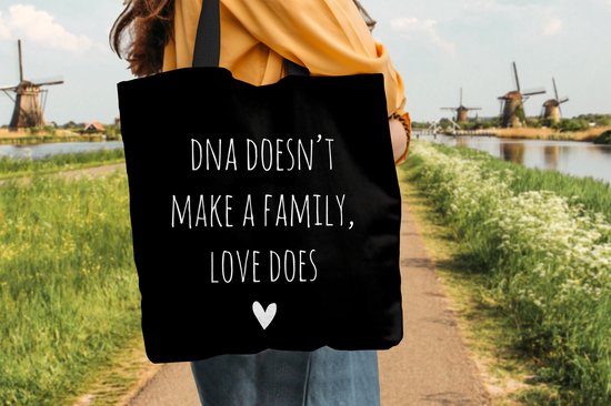 MuchoWow® Schoudertas - Strandtas - Big Shopper - Boodschappentas - Engelse quote "DNA doesn't make a family, love does" met een hartje op een zwarte achtergrond - 45x45 cm - Katoenen tas