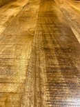 Gros plan d'un plateau de table en bois à l'aspect naturel et rustique.