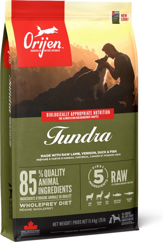 Orijen Tundra hondenvoer zak met man en hond op berg bij zonsondergang.