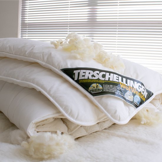 Wit wollen dekbed met schapenwol decoratie, met label van Terschellinger Wolweelde.