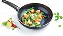 Zwarte wokpan met zalm, sperziebonen, peultjes, rode peper en limoen.