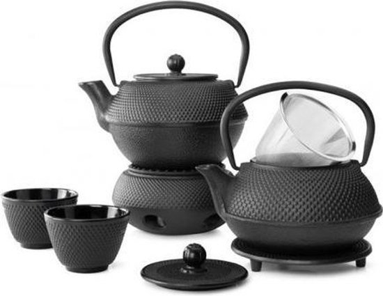 Zwarte gietijzeren theepot met decoratieve textuur, met een grote theepot, een kleinere theepot, twee kopjes en een warmhoudplaat.