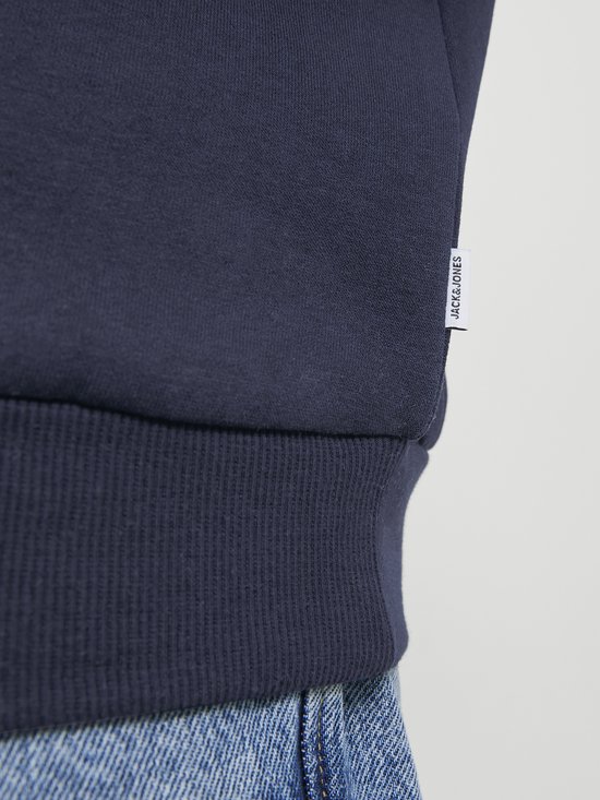 Close-up detail van een donkerblauwe hoodie met een geweven label met 'JACK&JONES' erop.