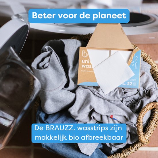 Witte wasstrips in een mand vol wasgoed, naast een geopende kartonnen verpakking. Duurzaam wasmiddel.