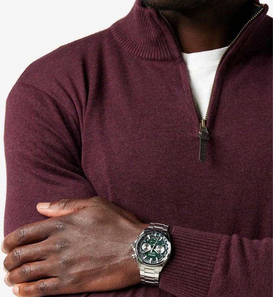 Man met een Seiko horloge om de pols, gedragen met een bordeaux trui.