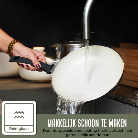 Witte pan met zwarte handgreep wordt schoongespoeld onder de kraan. Reinigbare parelcoating.