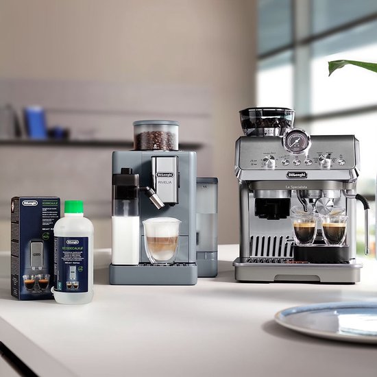 Opstelling van twee De'Longhi koffiemachines, een fles ontkalker en glazen espresso.