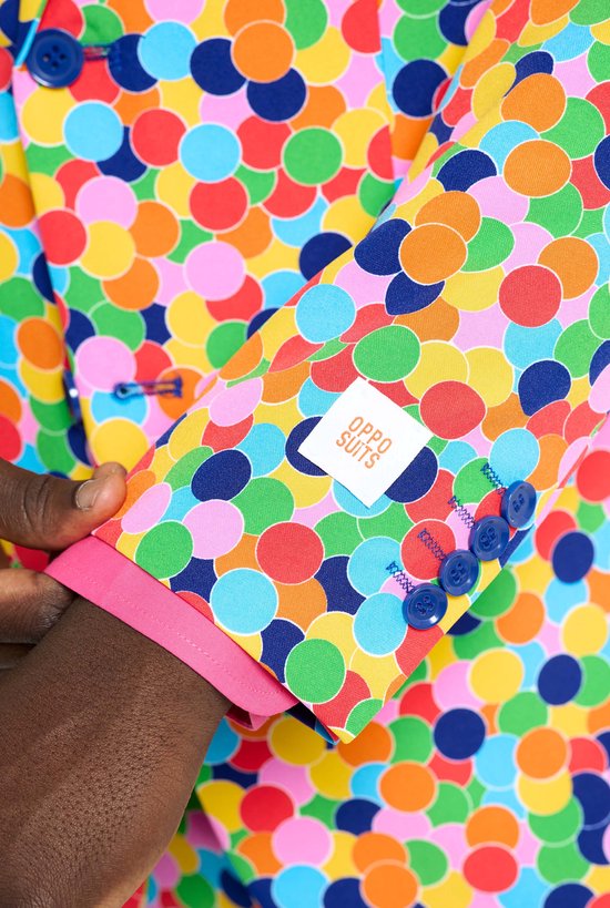 Close-up van de mouw van een kleurrijk confettipak, met een OppoSuits label en blauwe knopen.