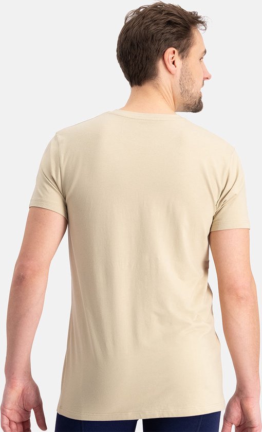 Man met kort bruin haar, met de rug naar de camera, in een lichtbruin T-shirt.