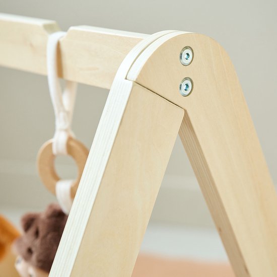 Close-up houten babygym met schroefverbinding.