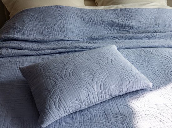 Lavendelblauwe mousseline spreideken met gestippeld rond patroon, met een bijpassend kussen.