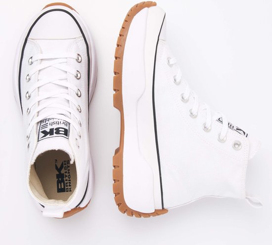 Paar witte hoge canvas sneakers, één van bovenaf met veters en logo, de ander opzij met dikke bruine zool.