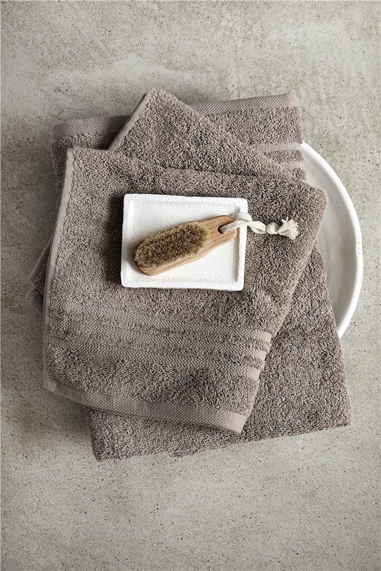 Serviettes d'invités taupe avec un porte-savon et une brosse.