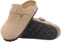 Paar sandkleurige suède Birkenstock clogs met gespen, één met de zool omhoog.