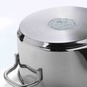 Close-up van de bodem van een roestvrijstalen pan met een rond merkembleem.