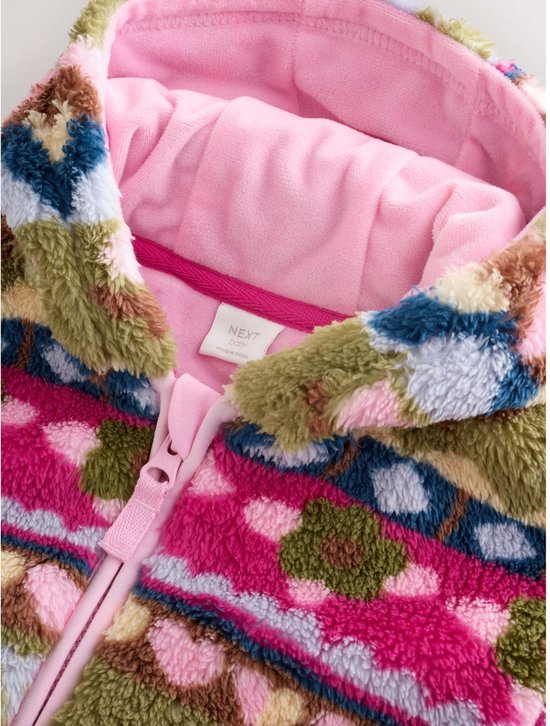 Close-up van de capuchon en kraag van het fleece babyjasje met roze voering en 'Next baby' label.