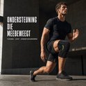 Man met zwarte kniebrace met groene accenten doet een lunge in een stedelijke omgeving.