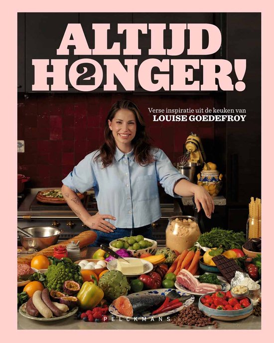 Een boek met de titel 'ALTIJD HONGER!' met Louise Goedefroy die leunt op een tafel vol verse ingrediënten.