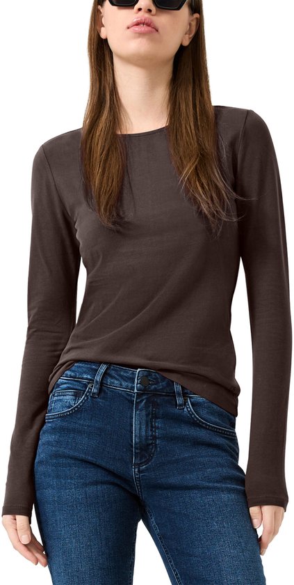Model in donkerbruine longsleeve met zonnebril en blauwe jeans.