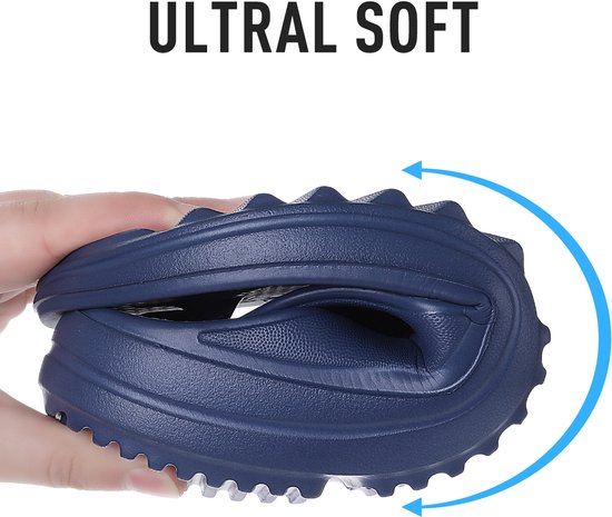 Hand die een opvouwbare marineblauwe OLANLY teenslipper vasthoudt om de flexibiliteit te tonen.