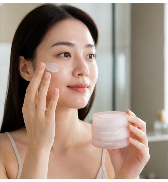 Een vrouw brengt Medicube Triple Collagen Cream aan op haar gezicht.