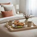 Houten dienblad met ontbijt op bed: mokken, toast, ei en fruit, met beige servies.