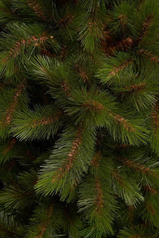 Detailopname van kunstmatige kerstboomtakken met groene naalden van hard pvc.