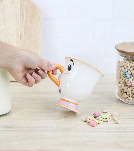 Mug blanc avec le visage de Chip, anse orange et base colorée.