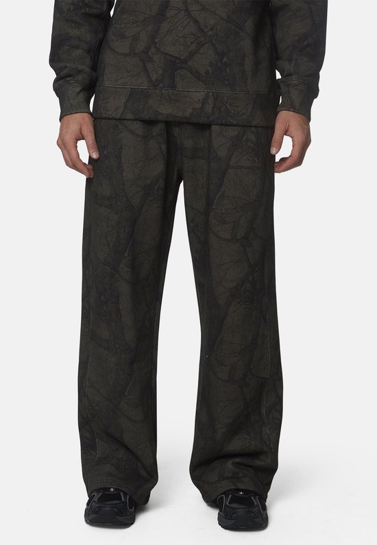Vooraanzicht van de benen van een man in een donkergroene joggingbroek met gebarsten patroon.