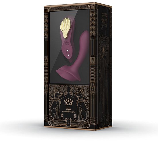 Vibrateur violet avec accents dorés et illustrations égyptiennes sur l'emballage.