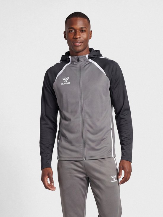 Man in stalen grijze Hummel hoodie met antracietkleurige mouwen en capuchon. Hummel logo op de borst.