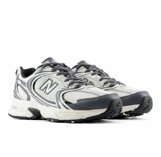 Grijze en witte New Balance sneakers met 'N'-logo's op de zijkant.