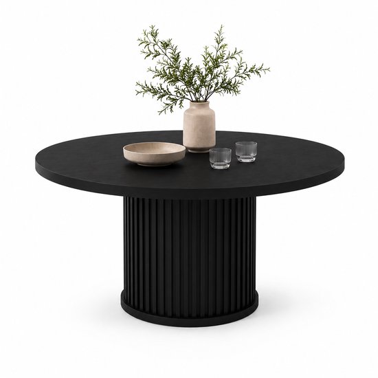 Zwarte, ronde eettafel met een gecanneleerd onderstel, gedecoreerd met een vaas met planten en twee glazen.
