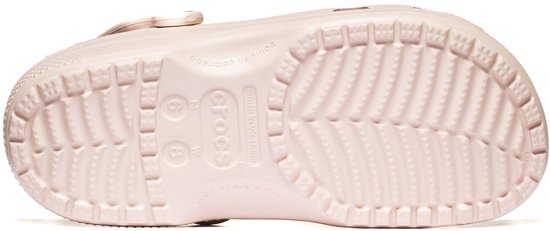 Onderkant van een lichte roze Crocs clog met profiel en het Crocs logo.