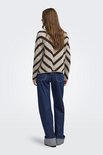 Achterkant van een lichtbruine trui met donkerbruine chevronprint, gedragen door een model met een witte blouse en jeans.
