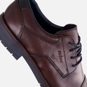 Detail van een bruine leren Rieker veterschoen met donkerblauwe veters.
