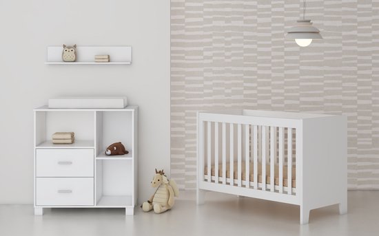 Witte babykamer met commode en ledikant. Op de commode een luierkussen en een knuffel. Op de plank een uil decoratie.