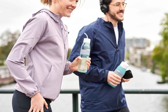 Homme et femme faisant du jogging avec des bouteilles, la femme en veste lilas, l'homme en veste bleu marine.