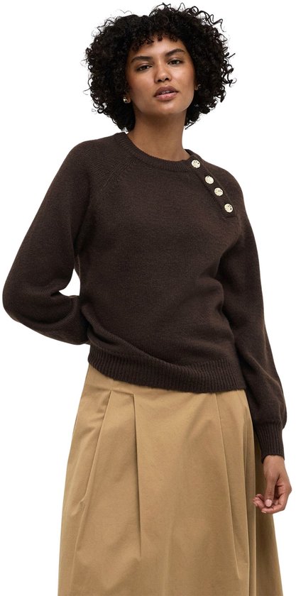 Model in donkerbruine trui met goudkleurige knopen, en camel rok.