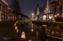 Stadsgezicht met kanaal en bruggen 's nachts, verlicht door lantaarns.