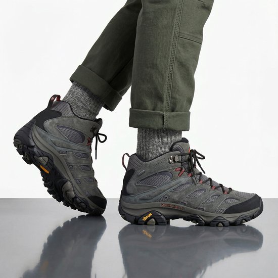 Man met grijze Merrell wandelschoenen met rode veters, Gore-Tex en Vibram zool.