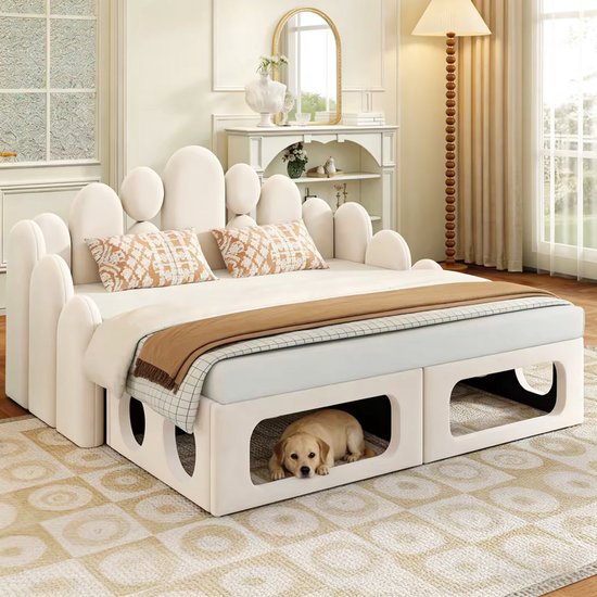 Beige slaapbank met twee kussens en een hondje dat uit de opbergruimte kijkt.