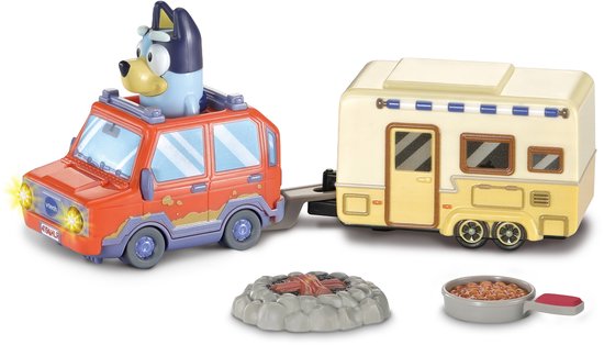 Blauwe Bluey in rode auto met caravan, kampvuur en pan met bonen. Auto heeft gele lichten aan.